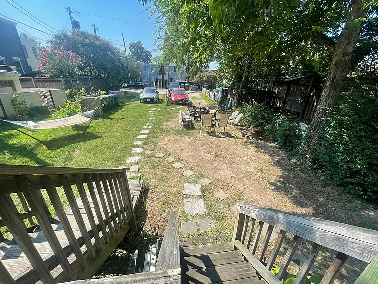 View of large double backyard from deck. Note the firepit and picnic table that is shared with other tenants. Private parking spaces in rear.
 You would also be welcome to plant a garden in this backyard if you like (the last tenants did). There is plen
