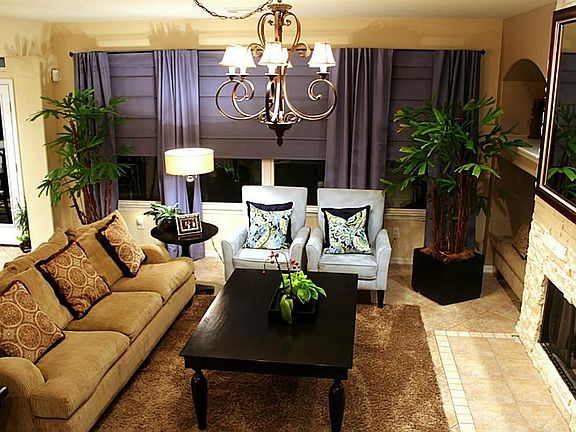 TAKE A LOOK AT THAT BEAUTIFUL STONE FIREPLACE SURROUND, CHANDELIER AND DECOR/PLANT SHELVES