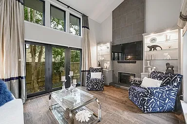 Living area with tons of windows, light, hardwood tile floors and beautiful lit built-in bookcases. TV's in home are already hung and connected; ready to go.