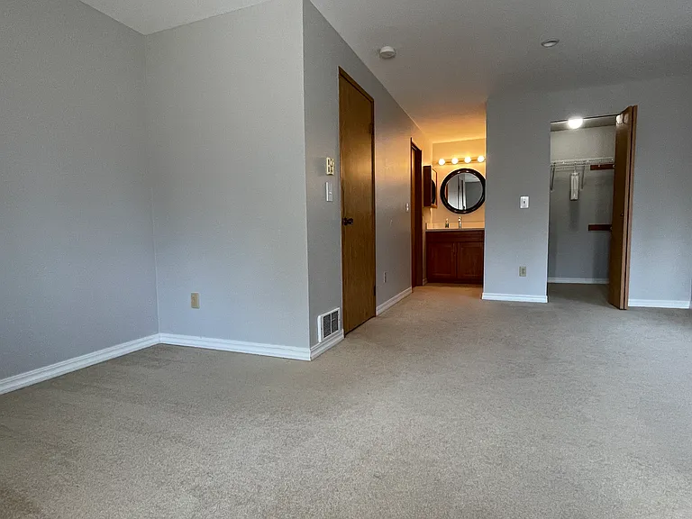 Main bedroom with entrance door, bathroom door, vanity, walk in closet