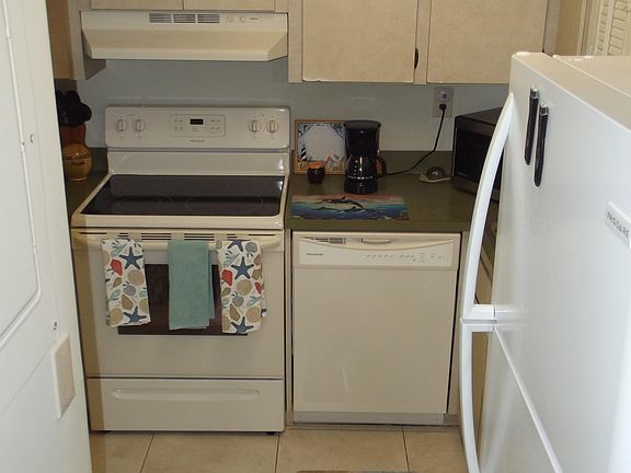 Kitchen with appliances, stove, dishwasher, microwave, refrigerator.