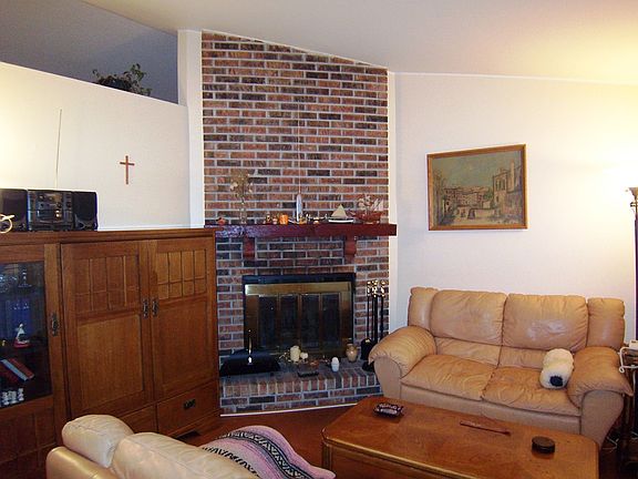 Living Room with Woodburning Fireplace and Vaulted Ceiling