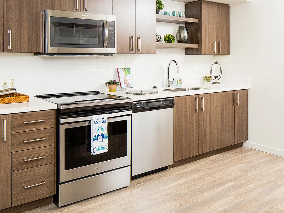 Sleek kitchen with stainless appliances and warm wood cabinetry.