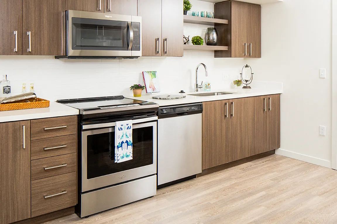 Sleek kitchen with stainless appliances and warm wood cabinetry.