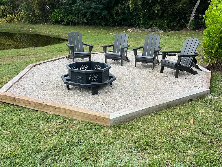 Fire pit located in back of pool to the right of pond