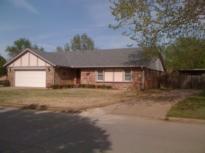Front view with extra drive way and fenced car port storage
