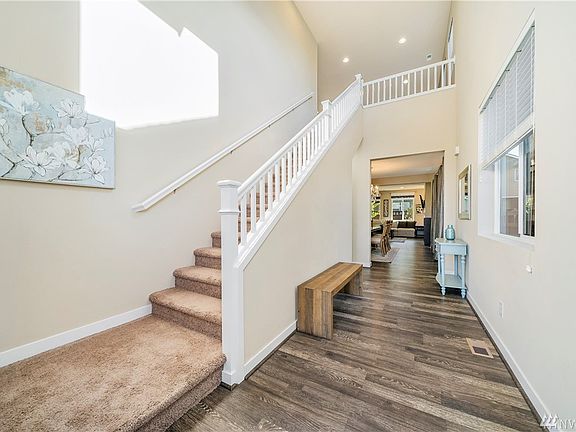 Entry with cathedral ceiling height and upgraded signature half railing up the stairs.