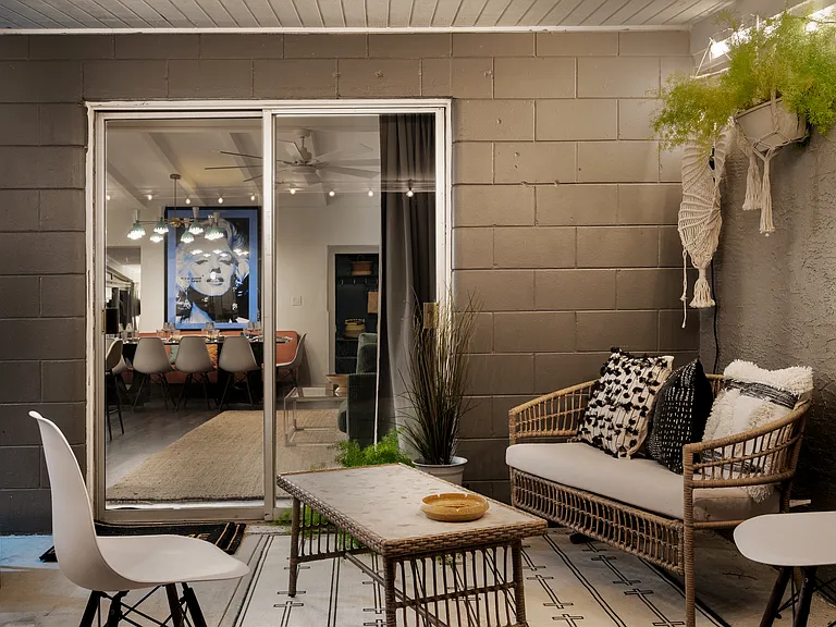 Seating area on covered porch off living room adjoining outdoor dining area - Night time