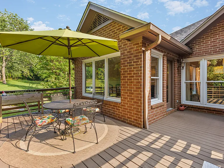 Outdoor dining table with seating for four and an umbrella on the upper patio off of the kitchen and dining areas.