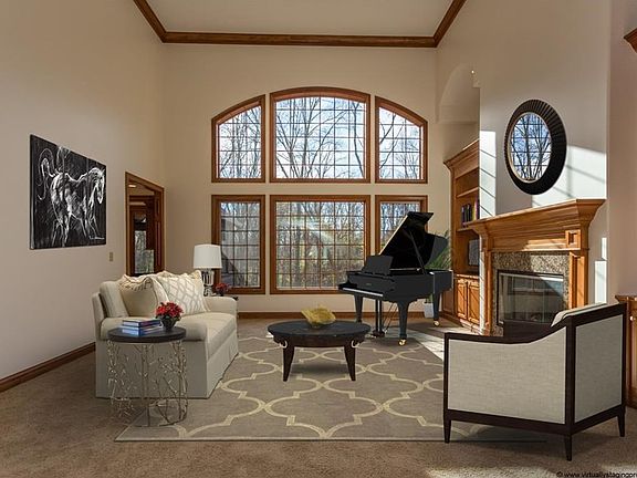 The jewel in the crown...virtually staged formal living room with built-ins finished with barrel ceilings, floor to ceiling windows and views of the expansive rear acreage. STUNNING to say the least!