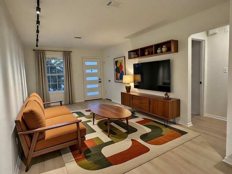 Large open floor plan living and dining area with elegant track lighting throughout.