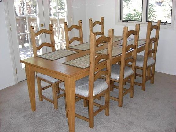 Dining area with French doors to deck and forest views.