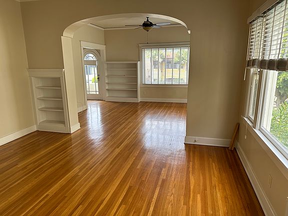 Dining room and living room viewed from kitchen door. Front patio glass door visible on left in background.