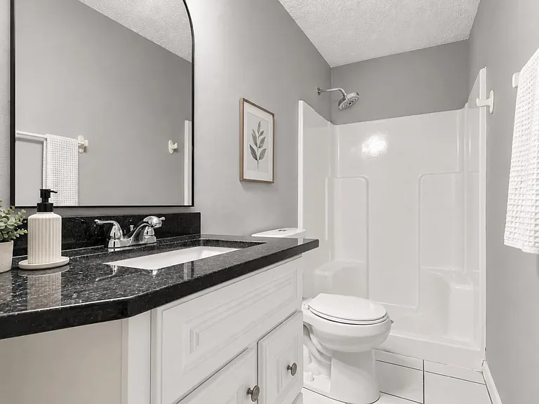 Full ground floor bathroom with shower and large granite vanity.