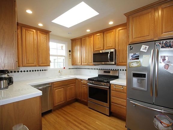 Kitchen with appliances and skylight. gas stove.
