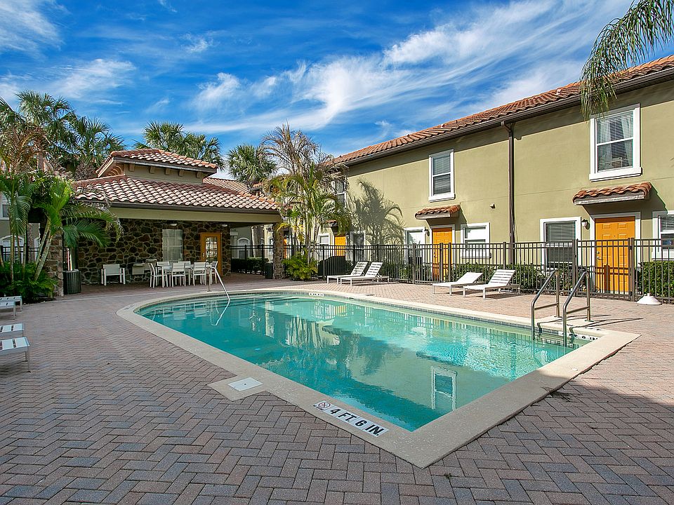 community pool with chairs, shaded area, and common space