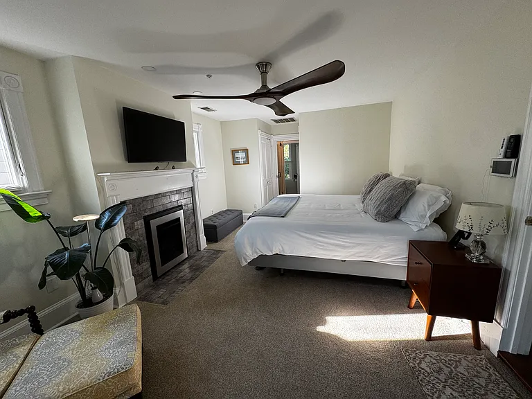 Primary bedroom with gas fireplace, small closet on back, left, smaller walk-in behind back wall.