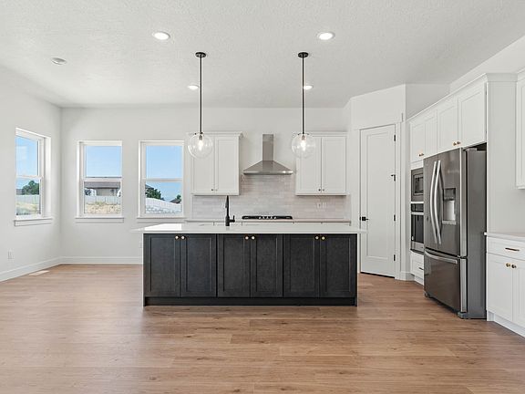 The kitchen has beautiful white wood cabinets, quartz countertops and energy-efficient appliances.