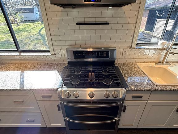 Chef's Galley Kitchen - SS Double Ovens/Gas Range with Vent Hood - Custom Cabinetry with Pull Out Drawers. 
Granite - White Cast Iron Sink - Subway Tile - Hardwood Floors.