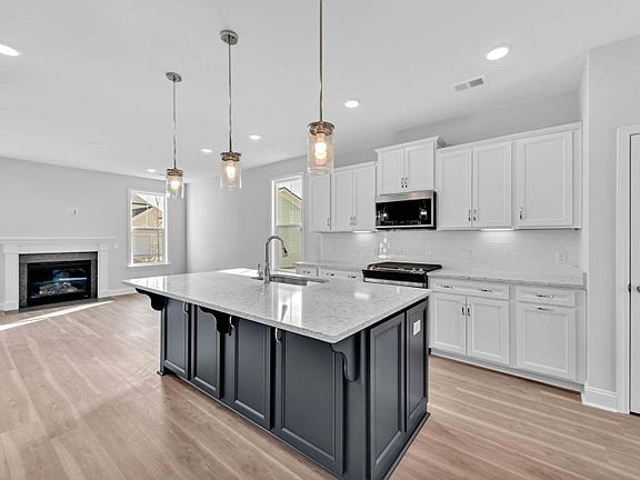 Watch the gentle glow of the fireplace in the Great Room off of the kitchen space.