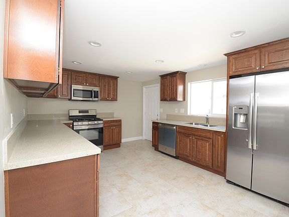 LARGE OPEN KITCHEN WITH QUARTZ COUNTER TOPS, NEW CABINETS, AND STAINLESS STEEL APPLIANCES
