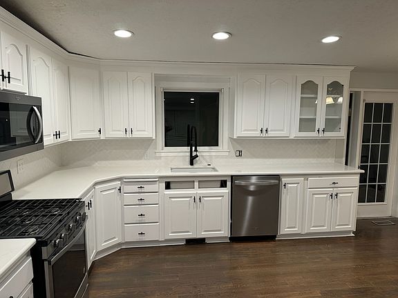 Large kitchen with plenty of cabinet space, and quartz countertops and hardwood floors.