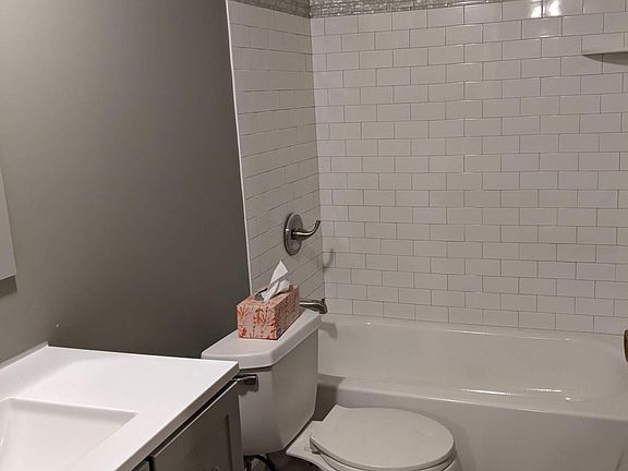 Newly remodeled bathroom with tiled shower walls. New bathtub, tile floor, painted walls, vanity, light fixtures. A lovely new bathroom.