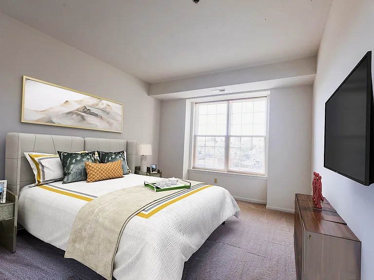 Spacious second bedroom with double closet and large windows with blinds.