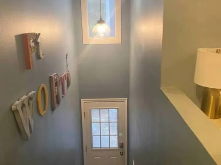 Natural light beams through this window to the staircase and comes with a cozy, "Fort Worth" sign.