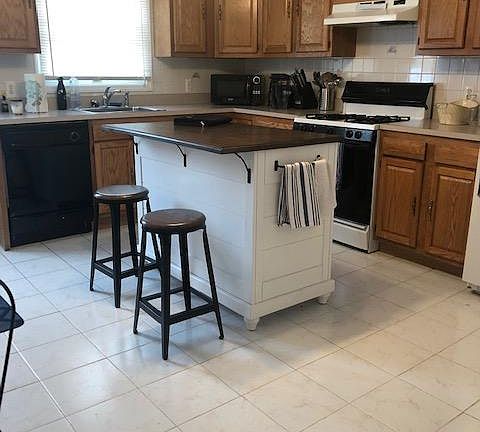 Kitchen features gas stove and dishwasher. Center island negotiable.