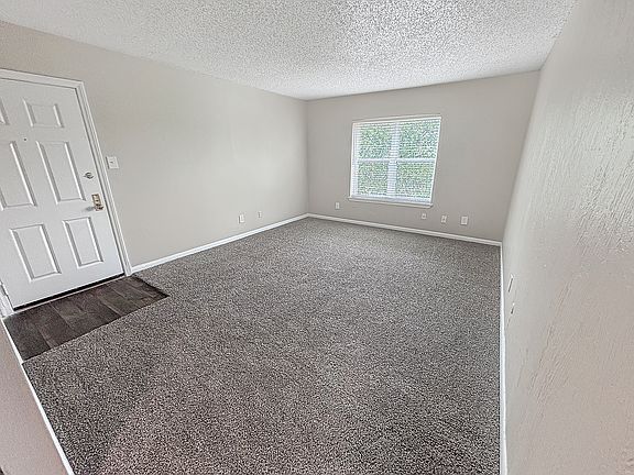 Soft carpet and natural light create a relaxing bedroom setting at Christy Estates Apartments.