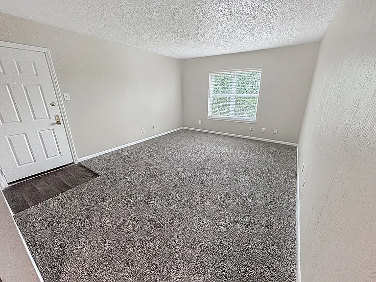 Soft carpet and natural light create a relaxing bedroom setting at Christy Estates Apartments.