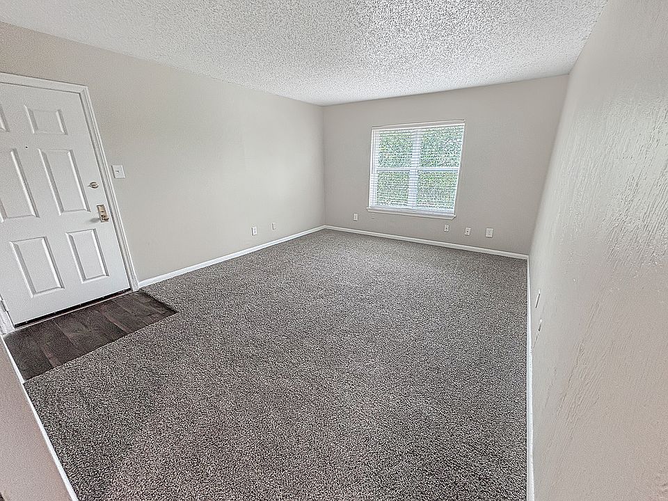 Soft carpet and natural light create a relaxing bedroom setting at Christy Estates Apartments.