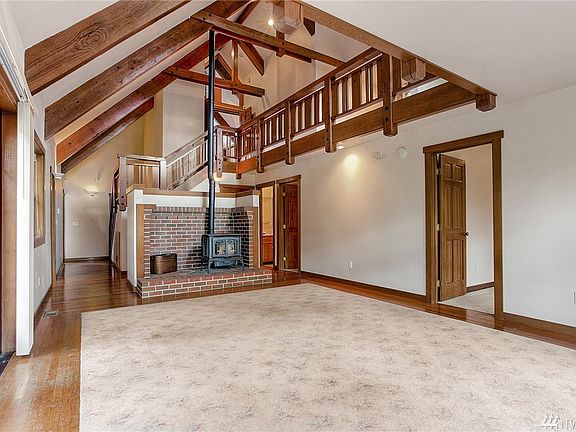 Soaring ceilings in the great room with cozy pellet stove surrounded by exposed brick.