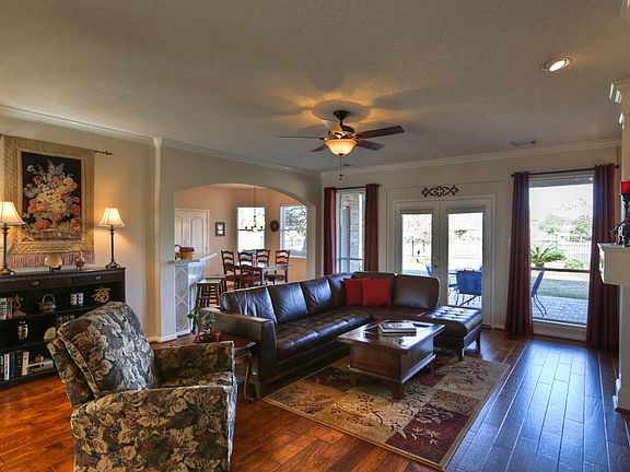 FAMILY ROOM [20X20] - This generously sized family room features hickory hardwood flooring and stunning lake views. French doors lead to the covered patio. A fireplace and custom niches display your art and media equipment with timeless flair.