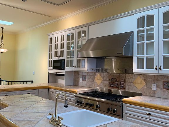 Kitchen with large island, stool seating, two sinks, skylights.