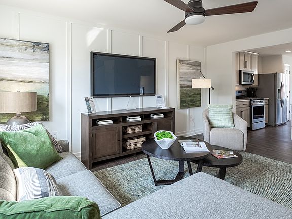 Living room and adjacent island kitchen in a DRB Homes York II model at the Archer s Rock community.