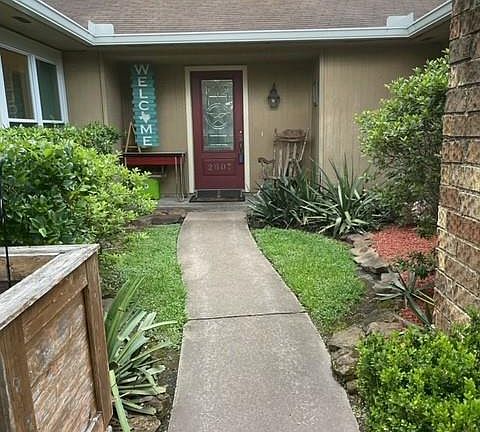 Yard professionally maintained with pretty trees and flowers.