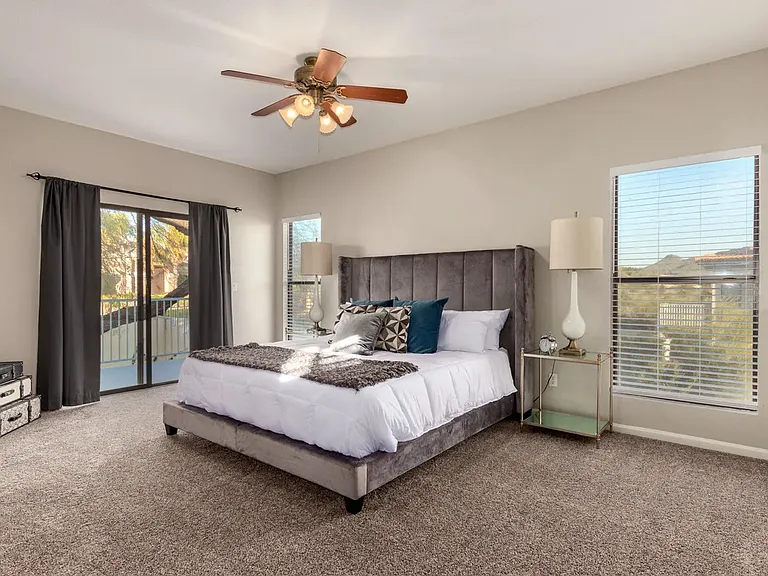 Large Master Bedroom with sliding glass doors existing to patio deck overlooking surrounding mountains