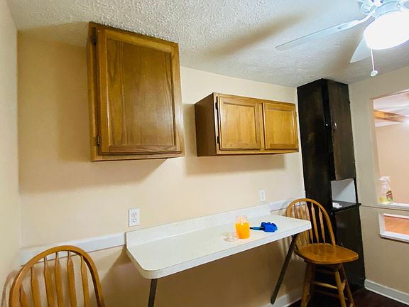 Kitchen with a bar/counter, 2 chairs and a ceiling fan and light