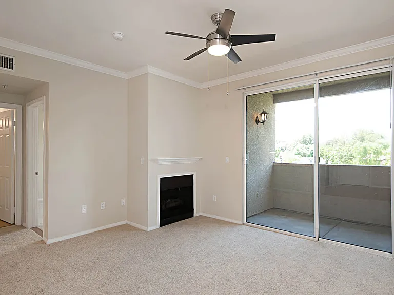 Carpeted Living Room with Fireplace and Balcony