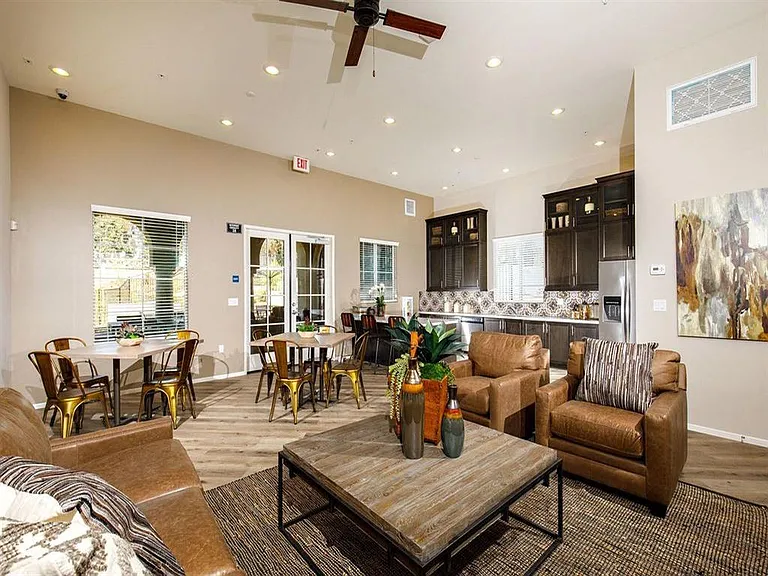 Club room with tables and kitchen with a refrigerator