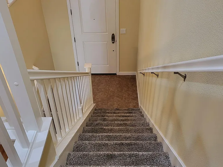 Staircase to go to the first floor, the stair case heading downwards leads to garage and the guest bedroom with attached bath