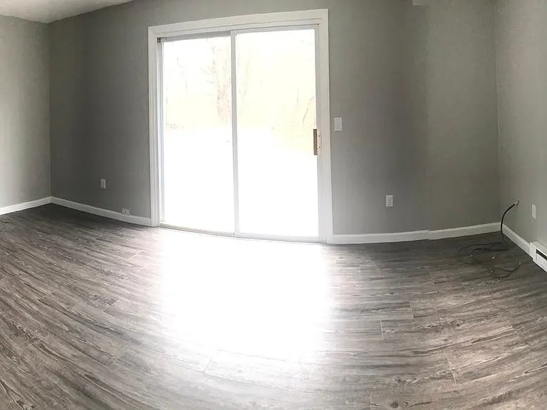 Large living room with private deck out sliding glass doors.
