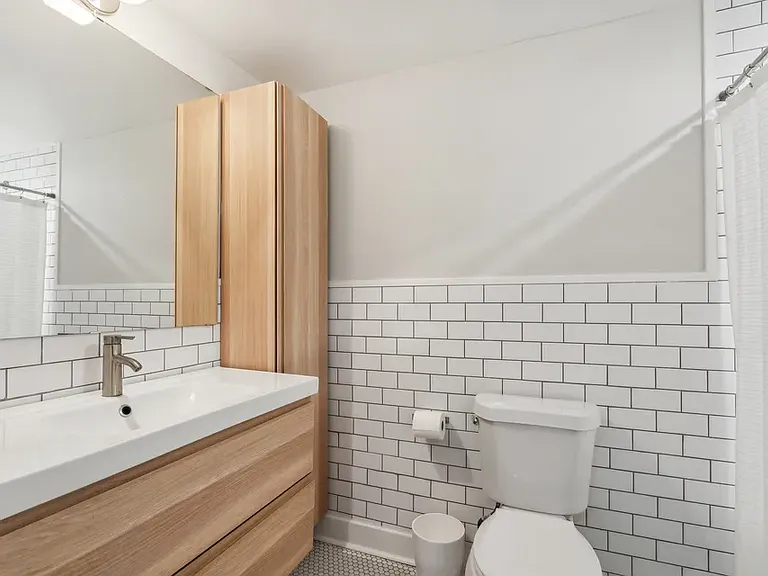 Primary bathroom. Shower curtain covers the bathtub on the right.