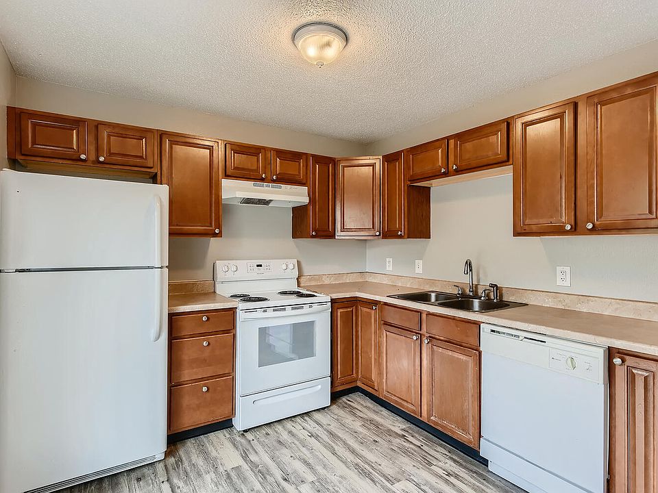 A kitchen with a refrigerator, range oven, dishwasher, and cabinets at Alder Square Rental Townhomes