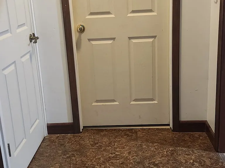 Apartment bedroom door, door to upstairs and opening to laundry/kitchen area
