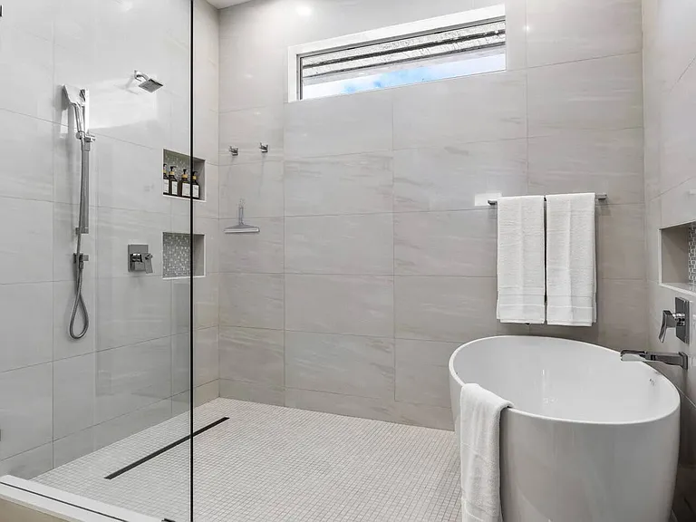 Unwind in the master bath with a freestanding soaking tub, spacious steam shower, and polished stone finishes