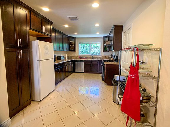 Kitchen with fridge, microwave, disaher and cooking utensils