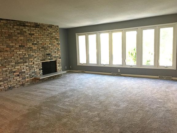 Living room has new carpet, wood burning FP, loads of window